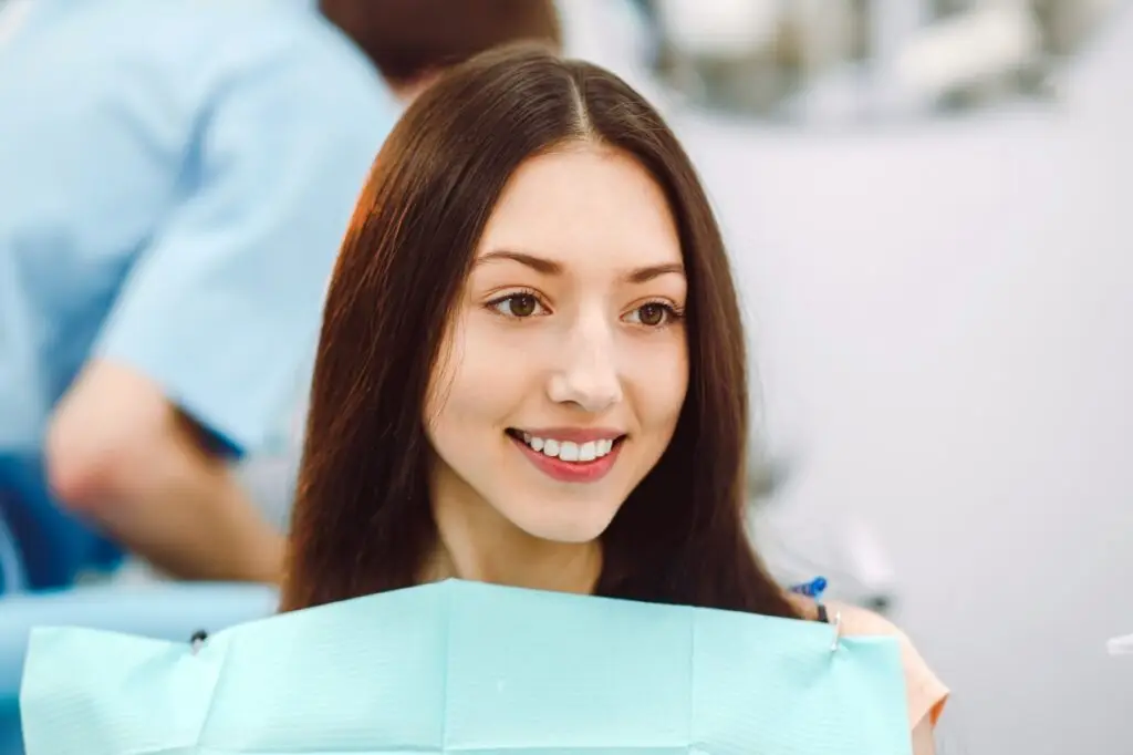 Smiling patient in a dental chair receiving professional scaling and polishing, highlighting a whitening and cleaning service at a dental clinic in Petaling Jaya.