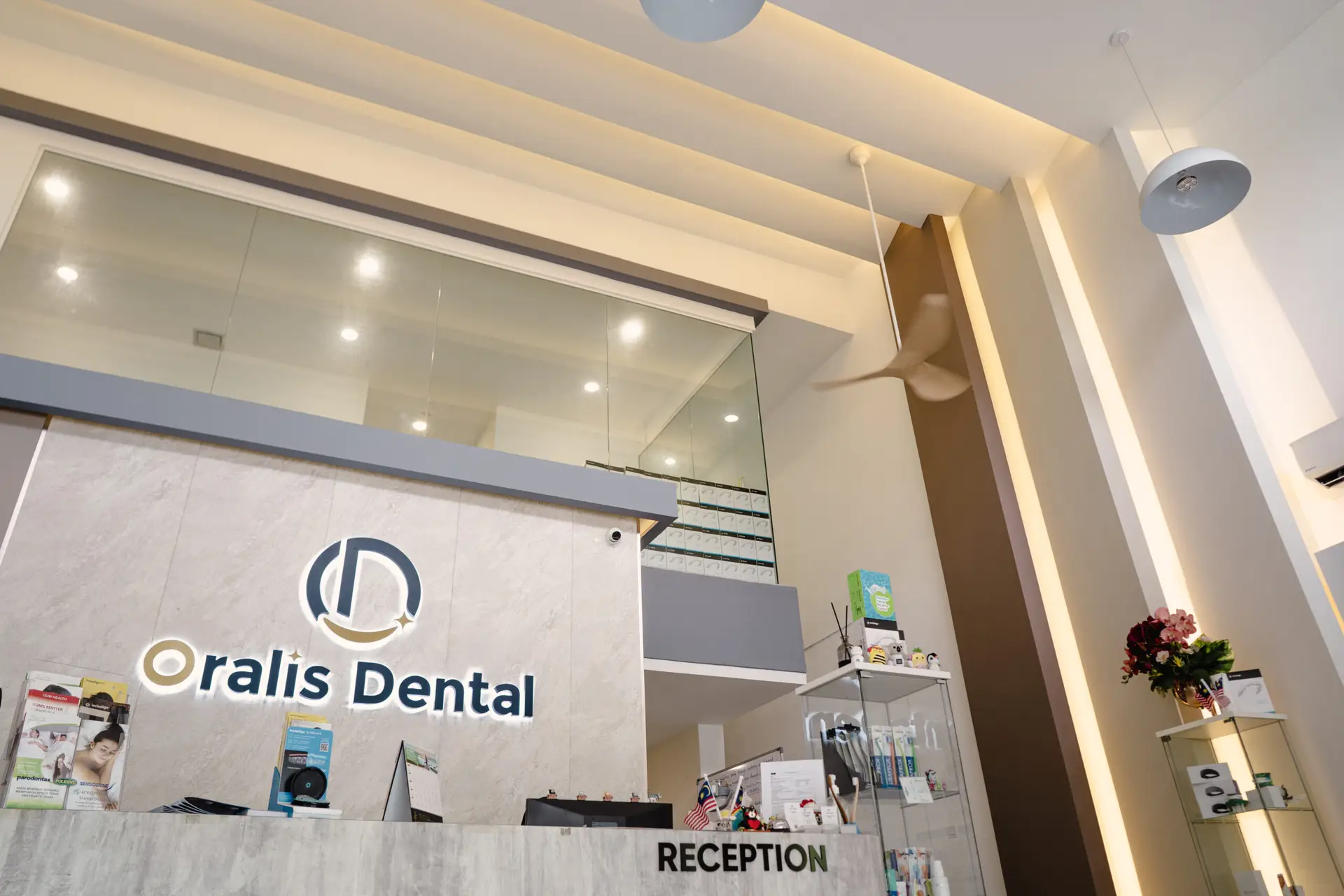 Welcoming reception area at Oralis Dental Petaling Jaya, featuring branded signage, high ceilings, and modern lighting.