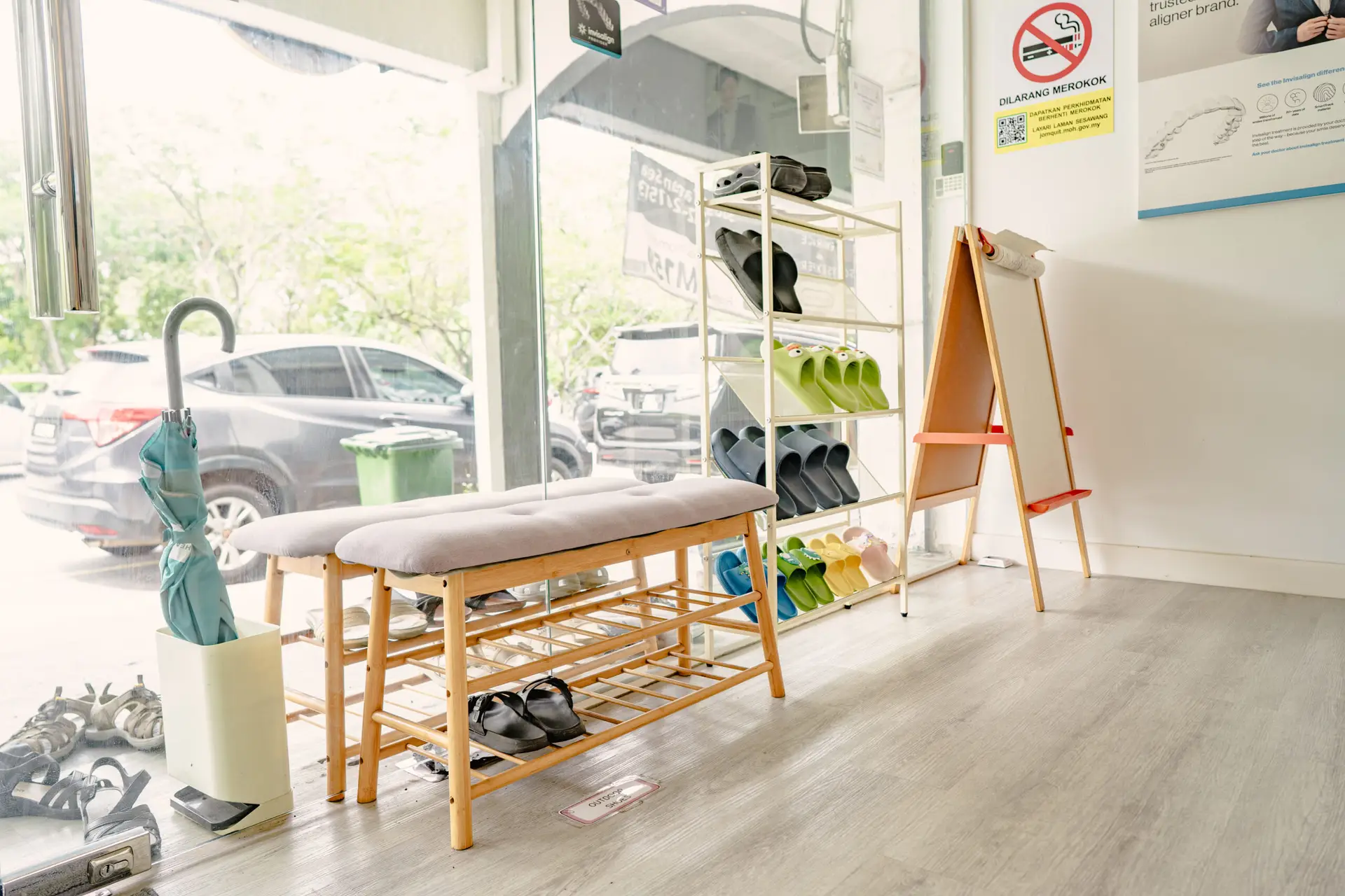 Clean and organized shoe-changing area at Oralis Dental Petaling Jaya, featuring indoor slippers and welcoming signage.